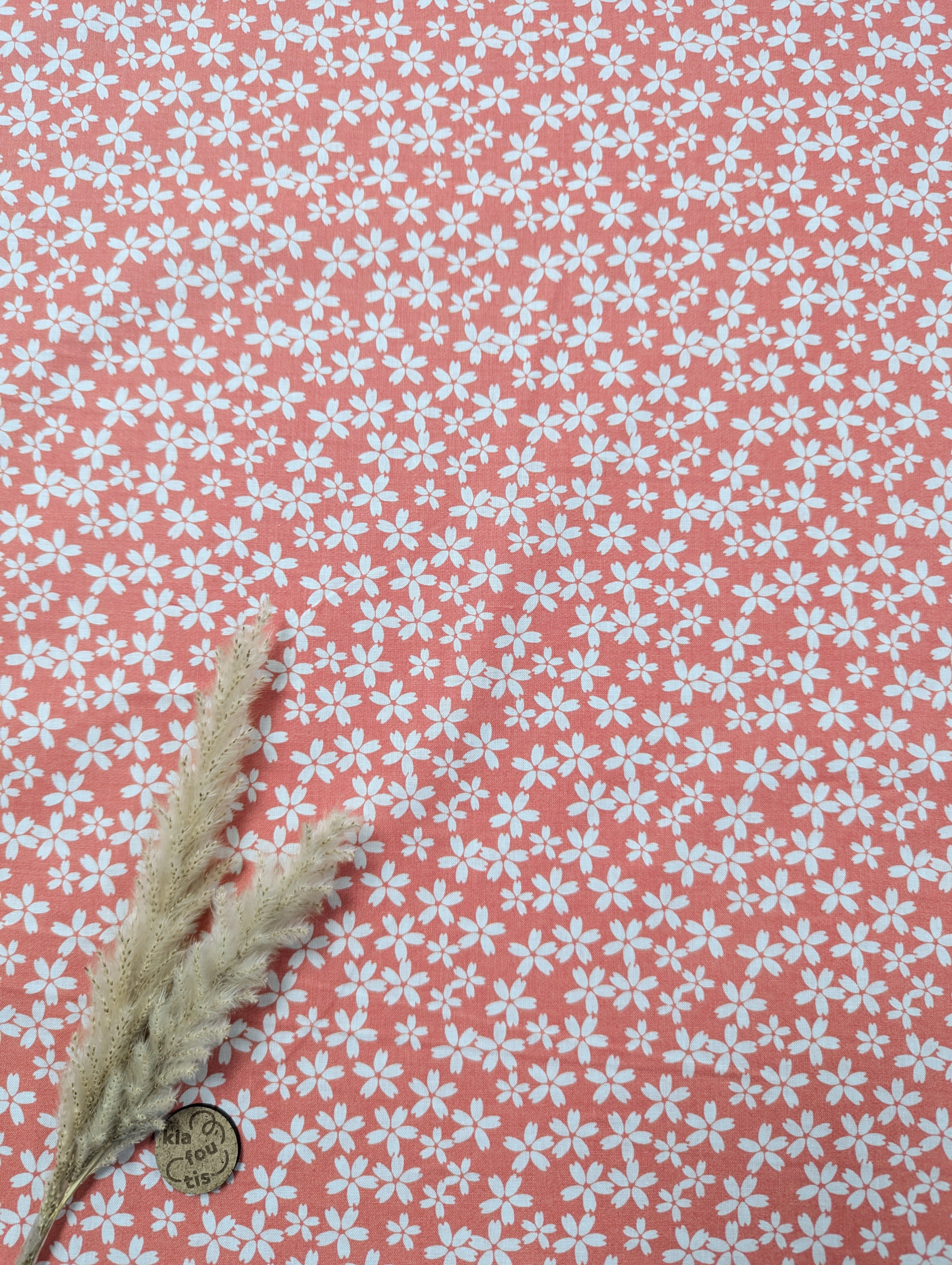 Popeline de coton rose corail - tapis de fleurs blanches
